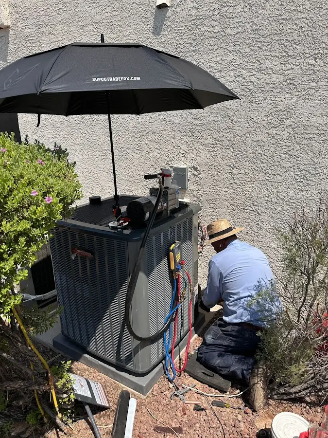 HVAC technician performing outdoor AC maintenance in Coolidge