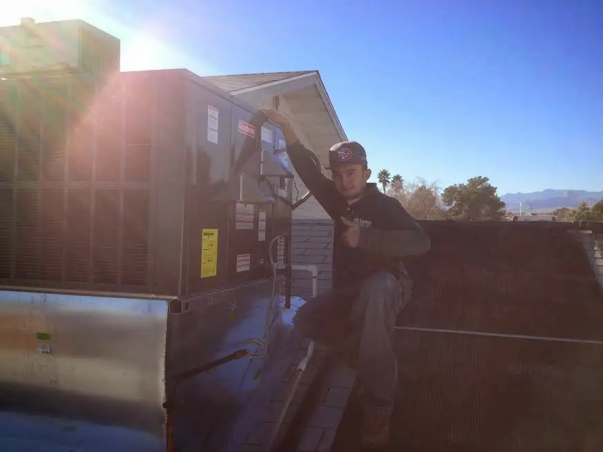 HVAC technician performing Boiler Repair on a rooftop unit in Coolidge